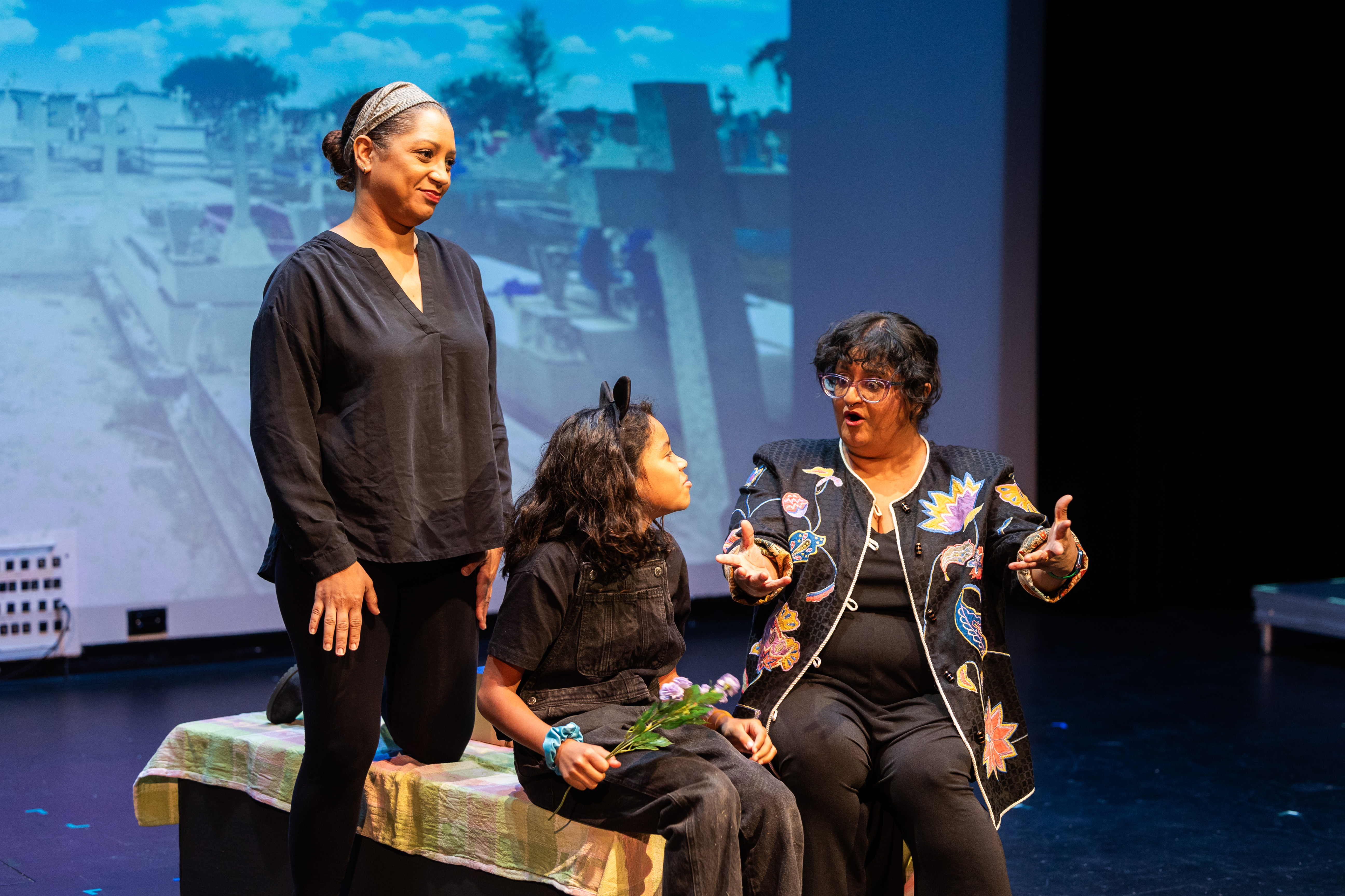 Image of a stage production with minimal props and three actors